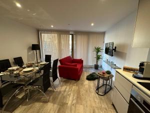 uma sala de estar com uma cadeira vermelha e uma mesa em LUXURY 2 Bedrooms - 2 BATHROOMS - F5 em Londres
