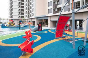 an outdoor playground with a slide and swings at Bali Premier Suites Melaka in Melaka