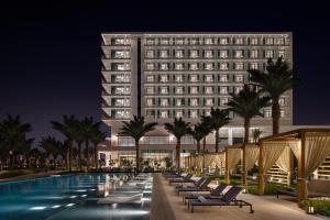 a hotel with a pool in front of a building at Address Beach Resort Bahrain in Manama