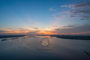 un logo della casa di nido sull'acqua al tramonto di Country Garden Theme Homestay by Nest Home at Danga Bay a Johor Bahru