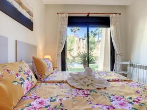 Una cama con una flor en ella con una ventana en Roda Golf Resort - 9309 en San Javier