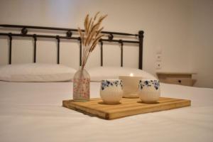 bandeja de madera con 3 jarrones en una cama en Liberty's House, en Mouresi