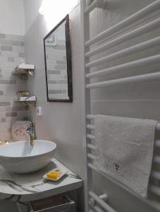 Baño blanco con lavabo y espejo en Liberty's House, en Mouresi