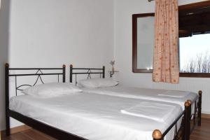sypialnia z łóżkiem z białą pościelą i oknem w obiekcie Liberty's House w mieście Mouresi