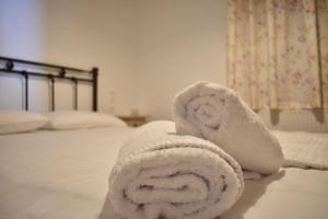 una pila de toallas sentadas en una cama en Liberty's House, en Mouresi