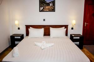 een slaapkamer met een groot bed met 2 nachtkastjes bij Surf & Party Weligama in Weligama