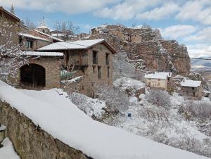 a village covered in snow on a mountain at Cal Ferrer Habitatge Rural in Cava