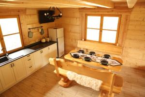 - une cuisine avec une cuisinière et un banc dans une cabine dans l'établissement Osada Stasiowe Chaty, à Stronie Śląskie