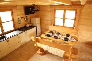 a kitchen with a stove and a bench in a cabin at Osada Stasiowe Chaty in Stronie Śląskie