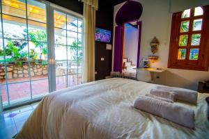 - une chambre avec un grand lit et une grande fenêtre dans l'établissement 16:9 Los Molinos Suites, à Almería