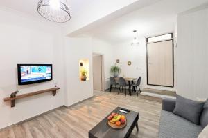 a living room with a couch and a tv and a table at Bella Ciao Guest House in Athens