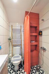 a bathroom with a toilet and a red wall at Bella Ciao Guest House in Athens