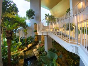 um jardim interior com uma escada e um lago em Urban Campfire Parc3 by Offweek em Kuala Lumpur