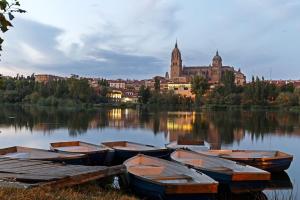 un grupo de barcos en el agua frente a una ciudad en Pensión Isabel by Vivere Stays, en Salamanca