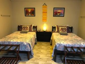 um quarto com 2 camas, uma mesa e um candeeiro em P & H Residence NorthGate em Chiang Mai