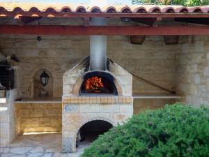a stone pizza oven in a patio at Family-Friendly Villa Erofili with Pool, Childrens Area & BBQ! in Astérion