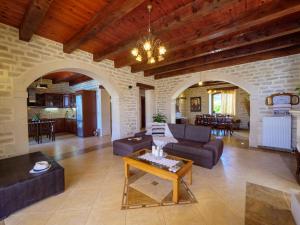 a living room with a couch and a table at Family-Friendly Villa Erofili with Pool, Childrens Area & BBQ! in Astérion