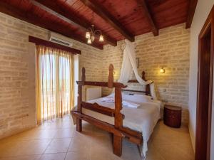 a bedroom with a wooden bed in a room at Family-Friendly Villa Erofili with Pool, Childrens Area & BBQ! in Astérion