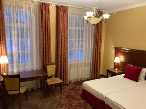 een hotelkamer met een bed, een bureau en een raam bij Guest House Pirklių Namai in Klaipėda