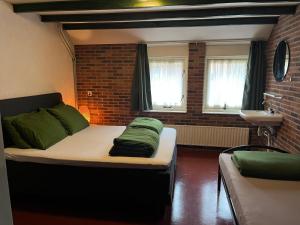 een kamer met een bed met groene kussens erop bij Familiehuis in Diever