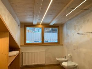 卡納澤伊的住宿－Appartamenti Chalet Orchidea，一间带卫生间、水槽和窗户的浴室