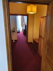 a hallway with a door open to a room at Hotel Polak in Zamość