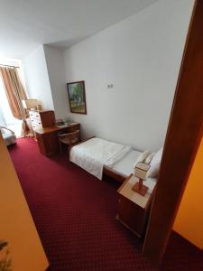 a hotel room with a bed and a desk and a room at Hotel Polak in Zamość