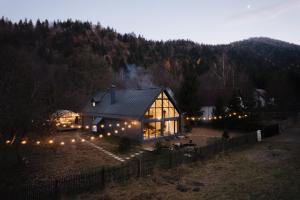 a large glass house with lights in a field at Cabana Sapte in Breaza