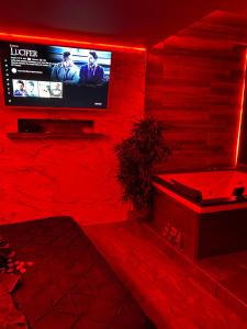 Suite morning star في لا سين سور مير: غرفة حمراء مع تلفزيون وحوض استحمام
