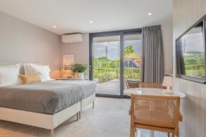 a bedroom with a bed and a view of a patio at Hello Zeeland - Summum Suites in Domburg