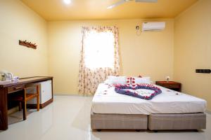 a bedroom with a bed and a desk and a window at Night Star Dhangethi in Dhangethi