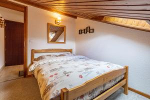 ein Schlafzimmer mit einem Bett in einem Zimmer mit einem Loft in der Unterkunft Le Forchat - proche des pistes in Bellevaux