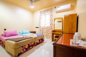 a hotel room with a bed and a mirror at Night Star Dhangethi in Dhangethi