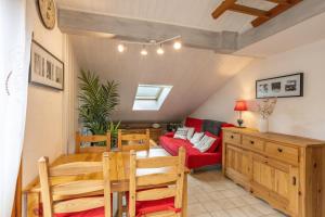 a living room with a table and a red couch at Le Forchat - proche des pistes in Bellevaux