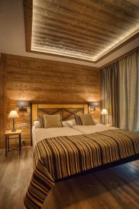a bedroom with a large bed with wooden walls at Apartmán Jelení Grúň Jasná in Belá