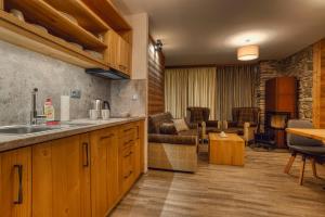 a kitchen with a sink and a living room at Apartmán Jelení Grúň Jasná in Belá