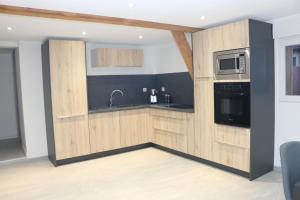 uma cozinha com armários de madeira, um lavatório e um micro-ondas em La grange de LIZ&EL em Osthouse