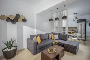 a living room with a gray couch and a table at Camelot Royal Beds by Estia in Malia