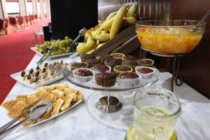 a buffet of food with muffins and fruit on a table at Garni Hotel Jugoslavija in Belgrade