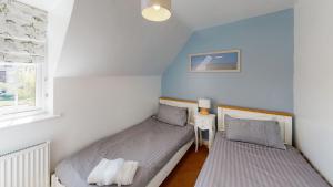 two beds in a small room with a window at Anchor Down at The Bay, sleeps 4-6 in 2 bedrooms, dogs welcome too in Filey +16 photos