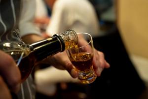 a person is pouring a glass of wine at Hotel Wohnen in Hakuba