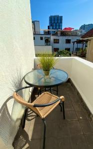 a glass table and a chair on a balcony at Hotel De Blasis in Santiago