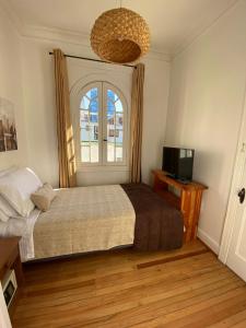 a bedroom with a bed and a window and a television at Hotel De Blasis in Santiago