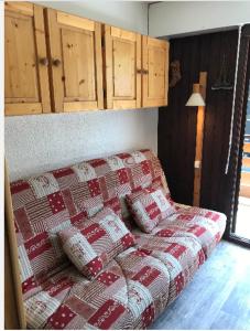 sala de estar con sofá y manta roja y blanca en La montagne « un coin d’oxygène » en Châtel