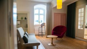 a living room with a couch and a red chair at Hotel Alexandra in Copenhagen