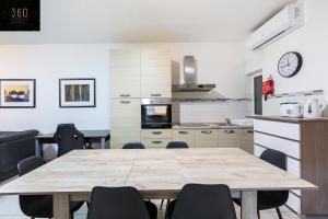 eine Küche mit einem großen Holztisch und Stühlen in der Unterkunft A lovely 3 Bedroom, 3 Baths home in the centre of Gzira by 360 Estates in Gżira