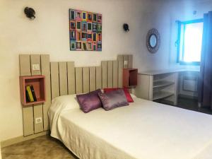 sypialnia z łóżkiem z fioletowymi poduszkami i biurkiem w obiekcie Villa I Merli Nous contacter avant réservation w mieście Saint-Florent