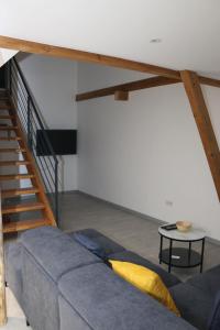 - un salon avec un canapé et un escalier dans l'établissement La grange de LIZ&EL, à Osthouse