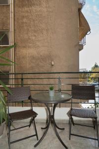 a patio table and two chairs on a balcony at Renovated Lovely Apt next to Marina Flisvos in Athens