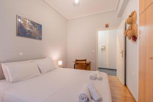a bedroom with a white bed and a teddy bear on the wall at Renovated Lovely Apt next to Marina Flisvos in Athens